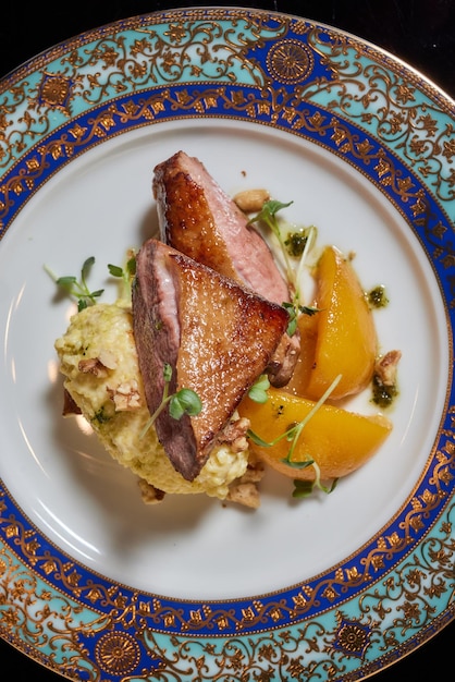 Plate with tender duck breast potato gratin and various vegetables