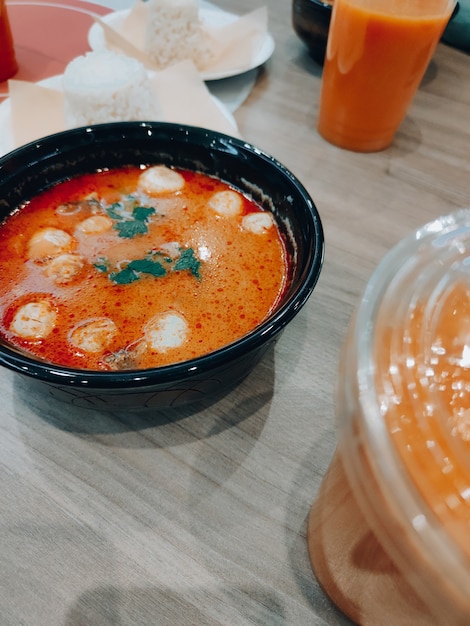 plate with tom yum and drinks on the coffee table