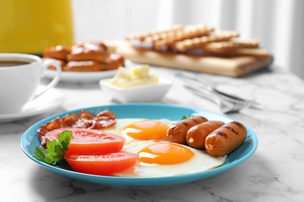 Plate with traditional English breakfast on marble table