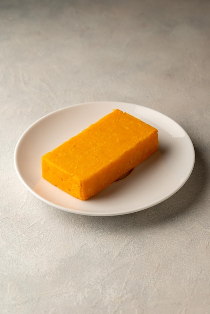 A plate of yellow turmeric sponge on a white plate.