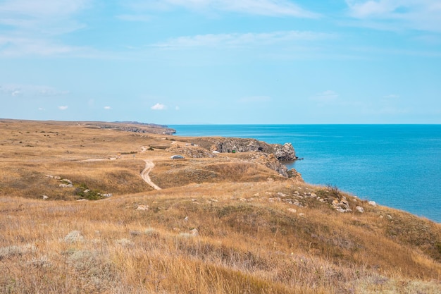 Plateau with dry grass and mountainous coast of the Sea of Azov Seascape