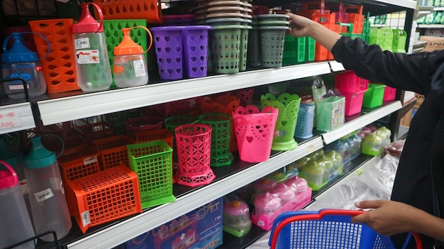 plates plastic buckets bowls food storage containers and kitchen utensils on supermarket shelves