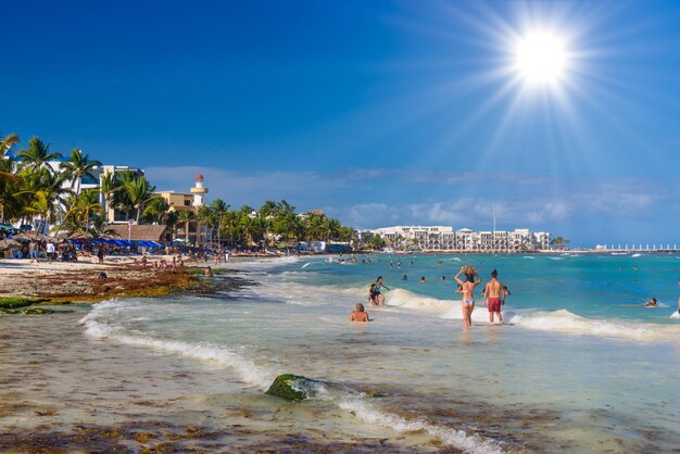 PLAYA DEL CARMEN MEXICO APR 2022 Pretty young girl in sexy brazilian bikini is walking and carrying her bag along the beach with waves