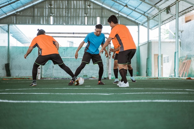 Players in blue uniforms snatch the ball from opposing players