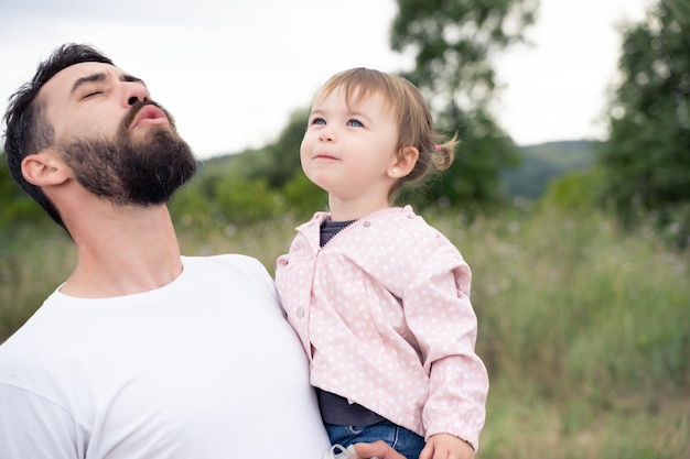 Playful father holding a little girl outdoors