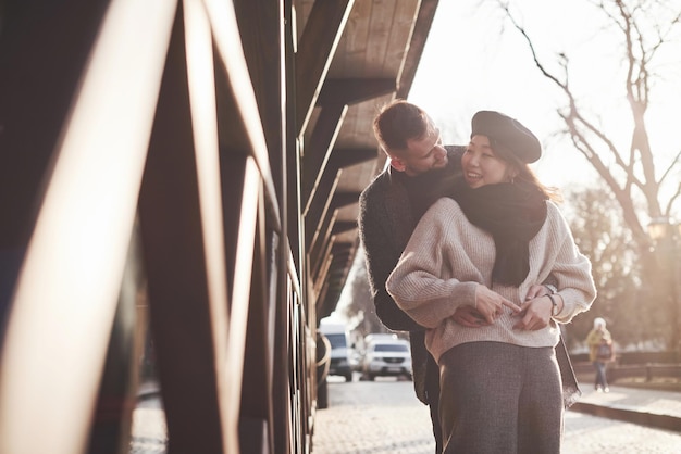 Photo playful and lovely multiracial couple together outdoors in the city. asian girl with her caucasian boyfriend.