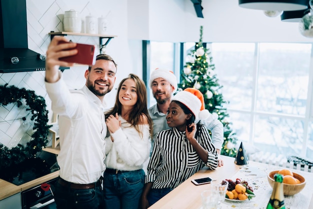 Playful multiethnic adult friends taking selfie at New year party