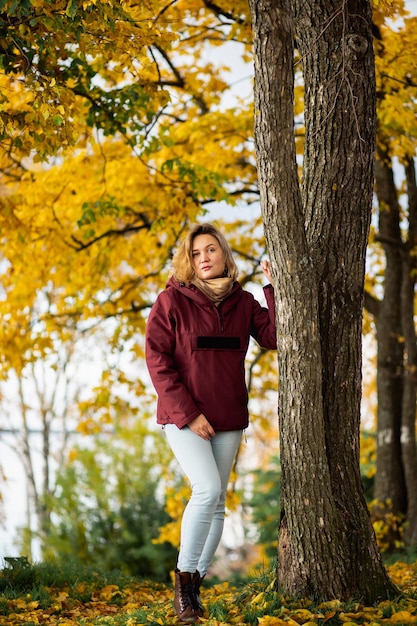 Playful young woman enjoying the fall yellow leaves in the autumn park people feelings seasonal dati