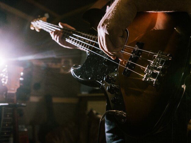 Playing bass guitar strings closeup