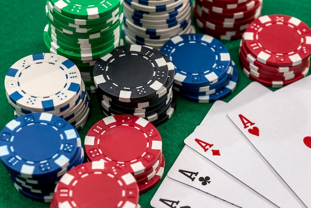 Playing cards and casino poker chips on green