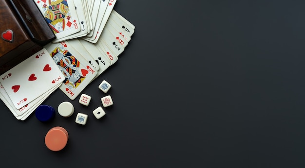 Playing cards and dice on a dark grey background