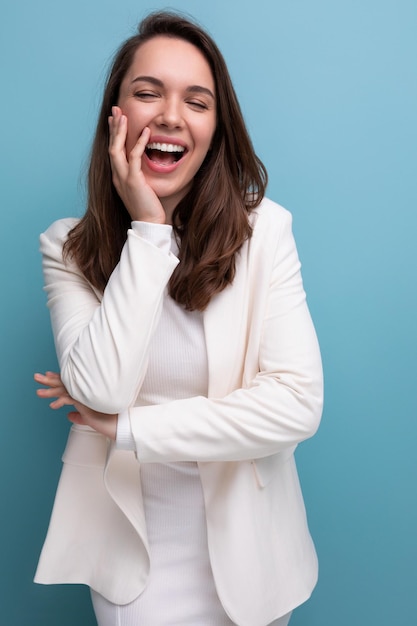 Pleasant european brunette young woman in a white dress with cheerful emotions on her face