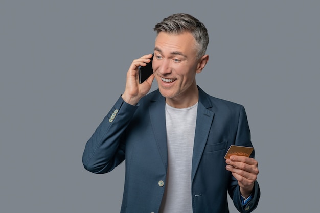 Pleasantly surprised man talking on smartphone