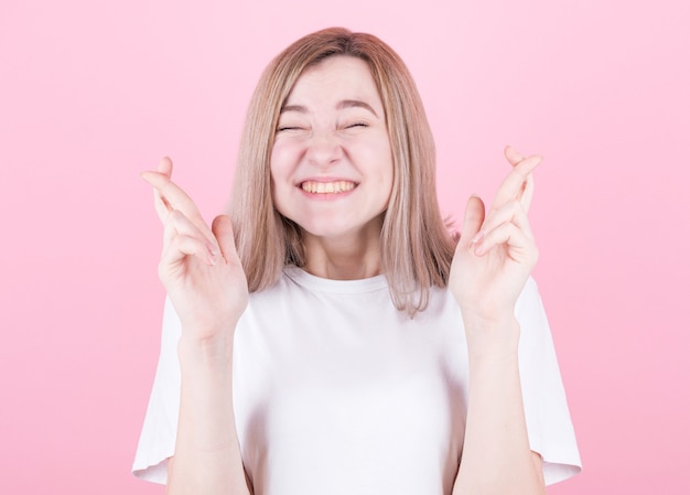 Pleased cheerful blonde woman puts all efforts in wishing good luck