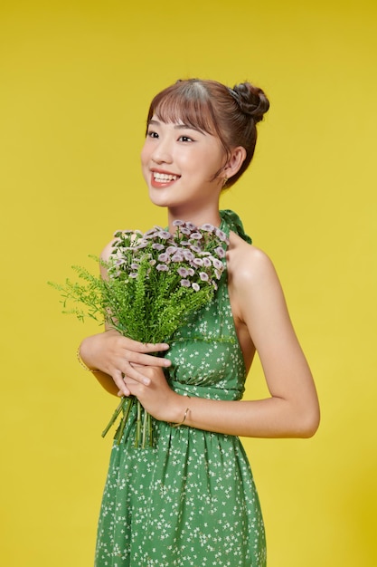 Pleased cute lady holds flowers closely to herself enjoys recieving bouquet