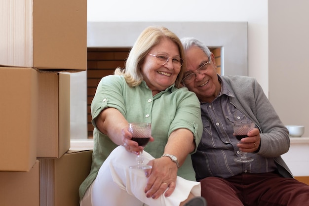 Pleased elderly couple celebrating moving into new house