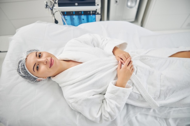 pleased female patient in a bathrobe looking up at the camera