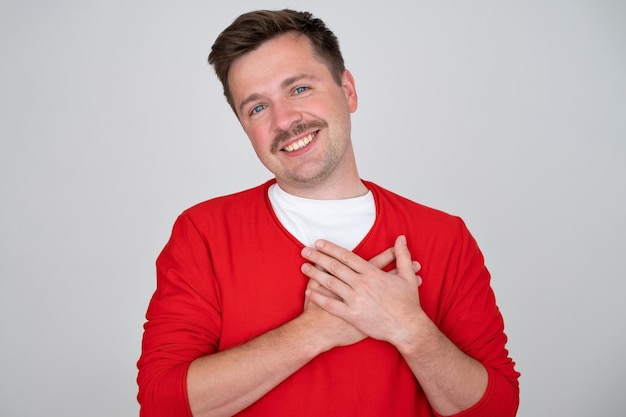 Pleased handsome male expresses his positive feeling to people who surround him