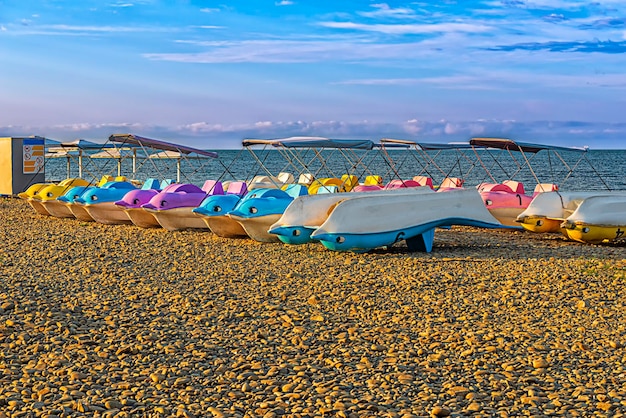 Pleasure catamarans on the shore of a deserted rocky beach