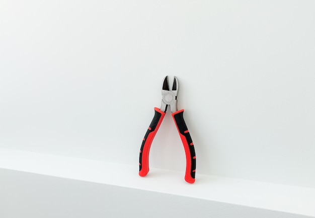 Pliers wire cutters in bright colors white background string construction tools clean tools isolated