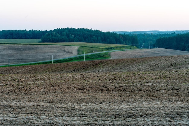 A plowed field against the sky The season of planting crops in a wheat field Preparing the field for planting rapeseed wheat rye and barley in rural areas