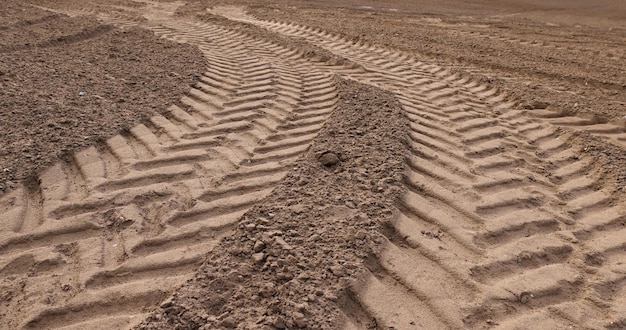 plowed soil of a field with traces of cars