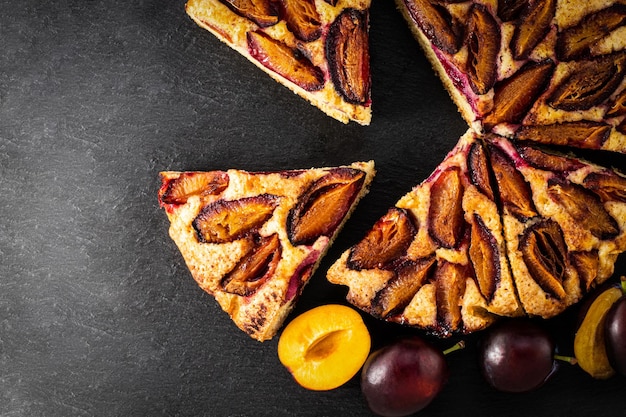 Plum cake on dark background top view