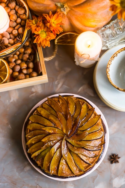 Plum cake decorated with sliced plum among the autumn decor 