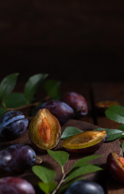 Plum cut in half on a wooden board