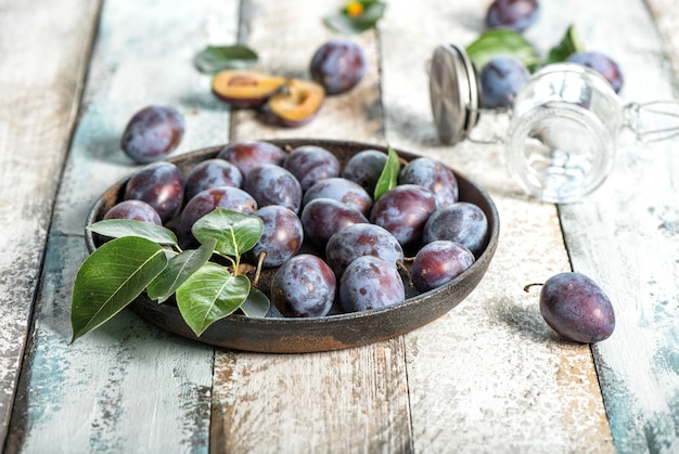 Plum fruits on rustic wooden background. Jam marmalade preparing