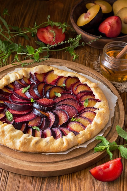 Plum Galette on wooden close up Homemade organic healthy dessert plum pie or french galette