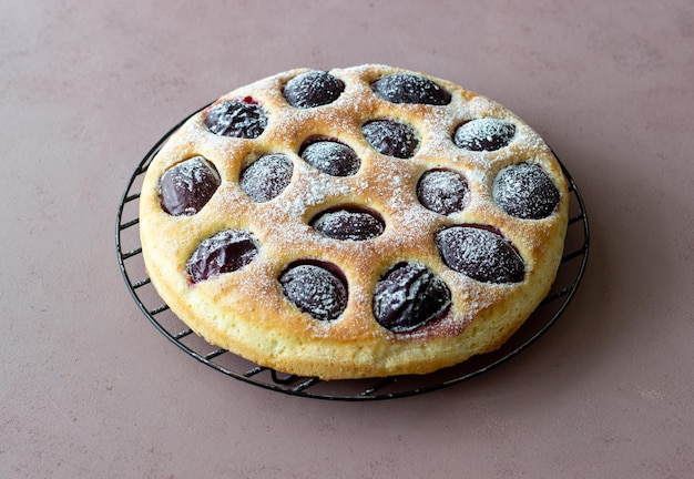 Plum pie on a pink background. Baking. Vegetarian food.