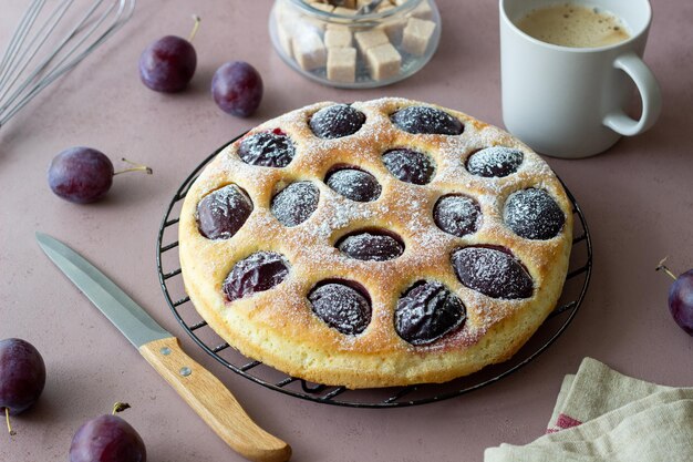 Plum pie on a pink background. Baking. Vegetarian food.