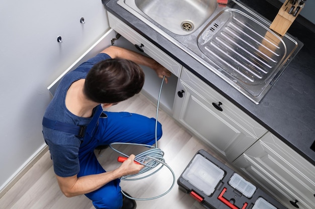 Plumber Cleaning Clogged Sink Pipe