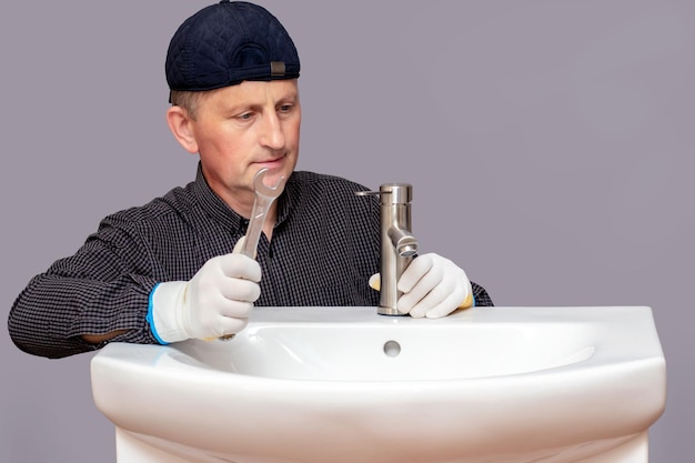 A plumber installs a faucet in a bathroom