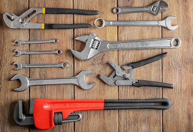 Plumber's tools on wooden background