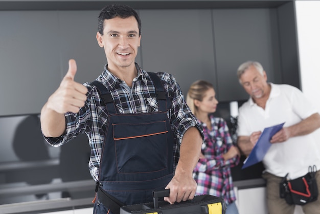 The plumber shows his thumb up and smiles.