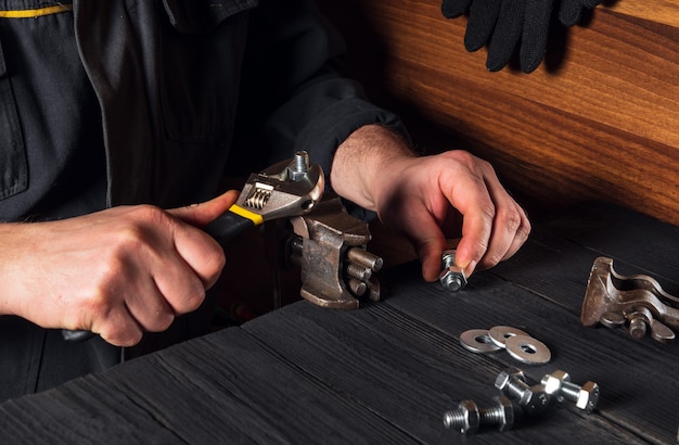 Plumber tightens the nut on the bolt with a plumbing wrench