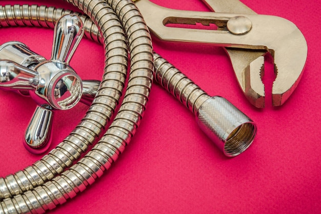 Photo plumbing materials faucet, tool and hose on purple space are used for replacement in the shower