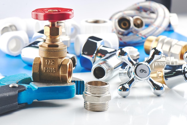 Plumbing parts, accessories and tools on a blue white background.