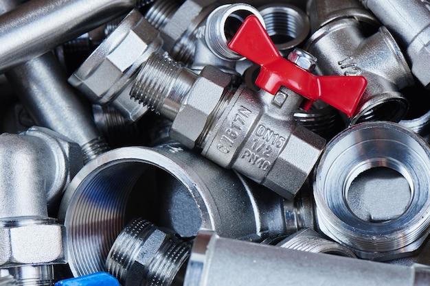 Plumbing parts and tools from metal. Red gas wrench and faucets. Close-up, top view.