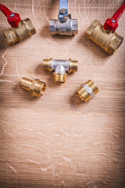 Photo plumbing tools brass pipe connectors on wooden board