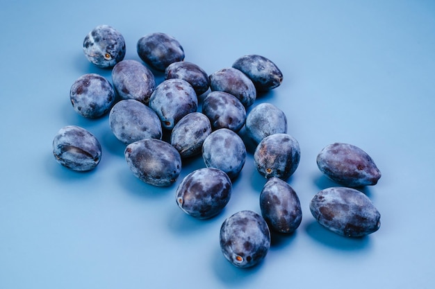 Plums on a blue background closeup top view