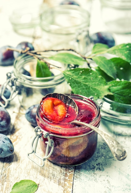 Plums jam in jar. Fruit marmalade. Vintage style toned picture