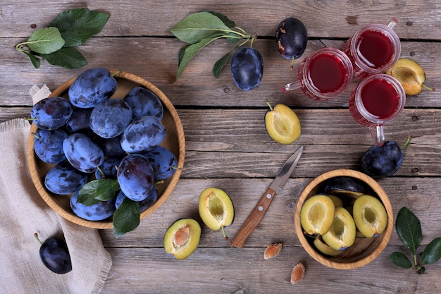 Plums and plum juice on a wooden table