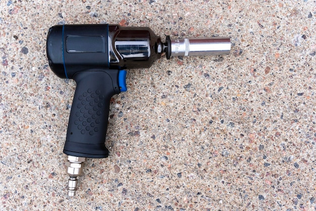 A pneumatic impact wrench with an end head on the concrete floor