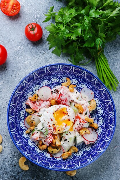 Poached egg salad with vegetables and cashew. Vegetable Salad top view with ingredients