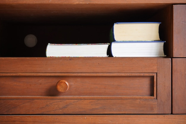 Pocket book in wooden cabinet shelf with empty blank dark background