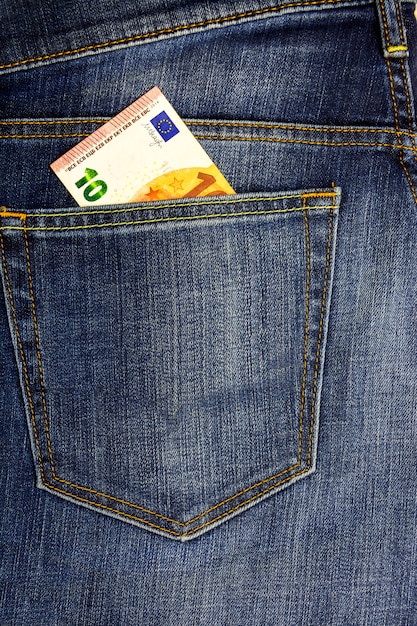 In the pocket of dark jeans inserted banknote 10 euro