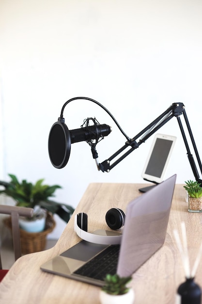 Podcast and blogging concept - modern workplace with laptop and microphone at radio station office